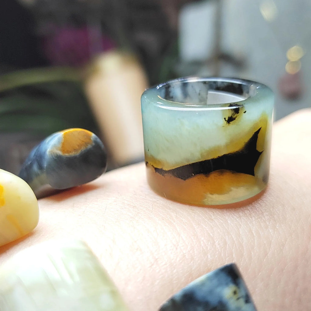 Translucent jade ring with multicolored patterns on a hand
