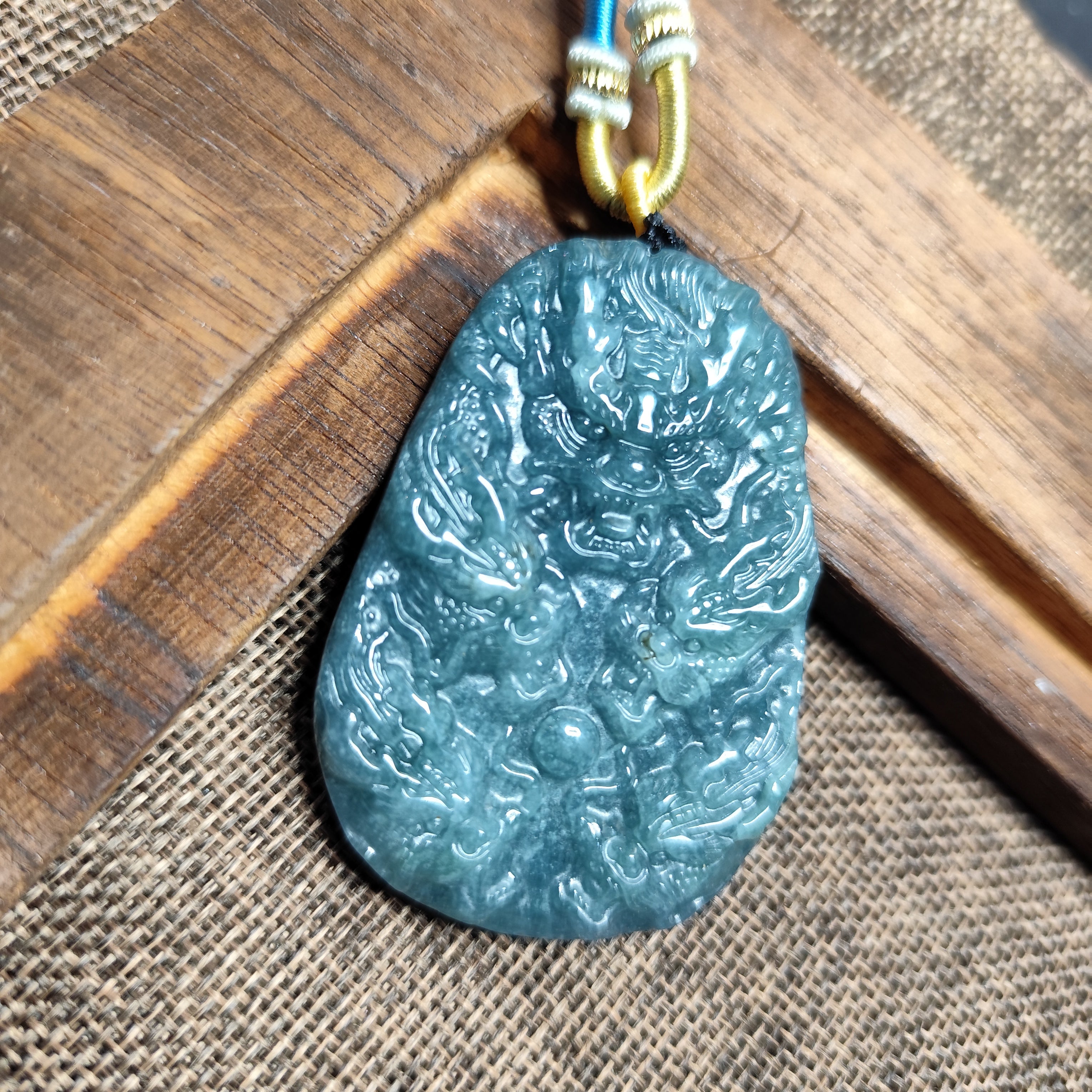 Blue jade pendant on a wooden surface